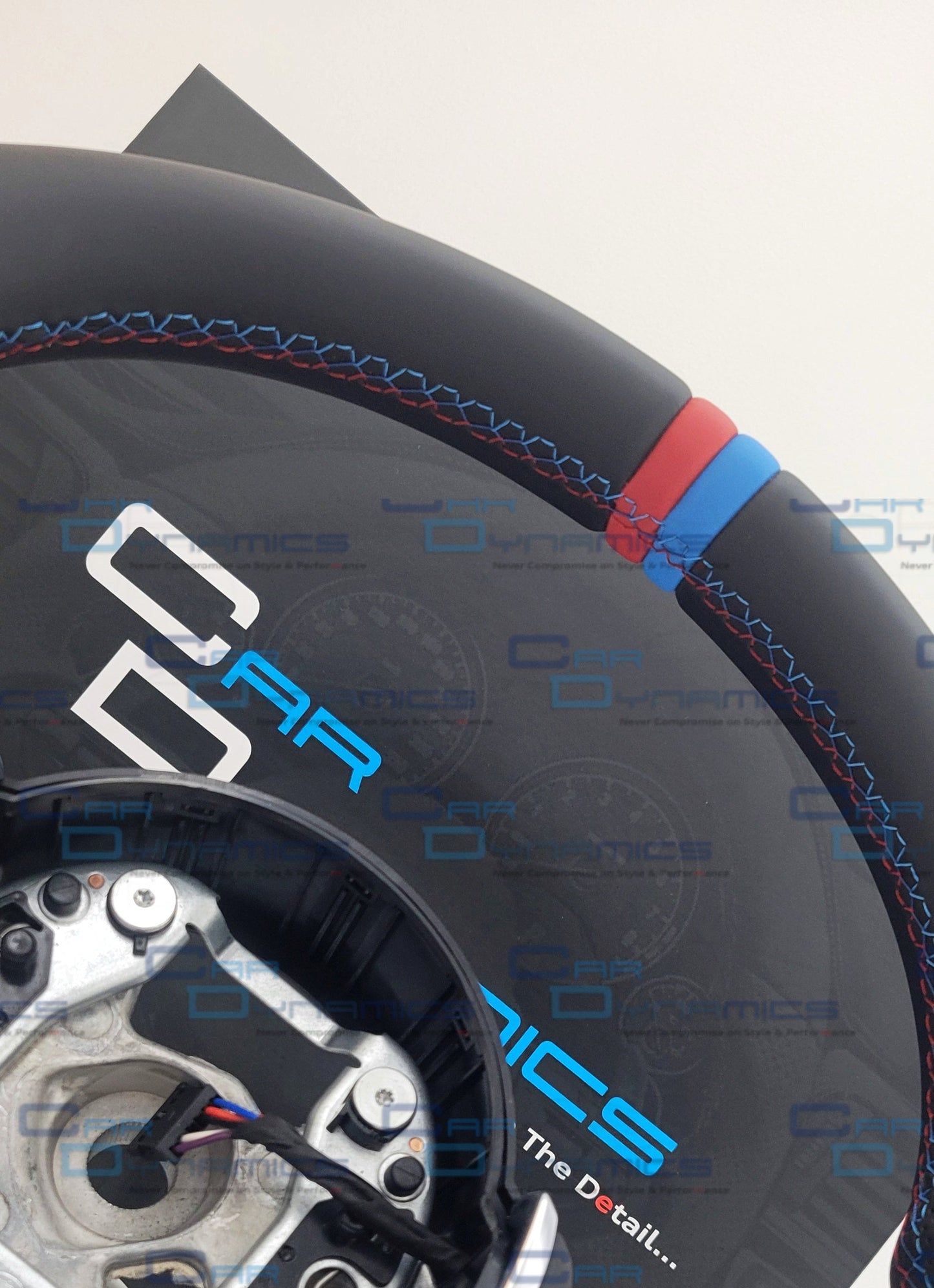 Close-up of a steering wheel with visible branding on a white background