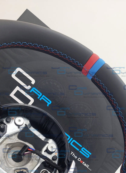Close-up of a steering wheel with visible branding on a white background