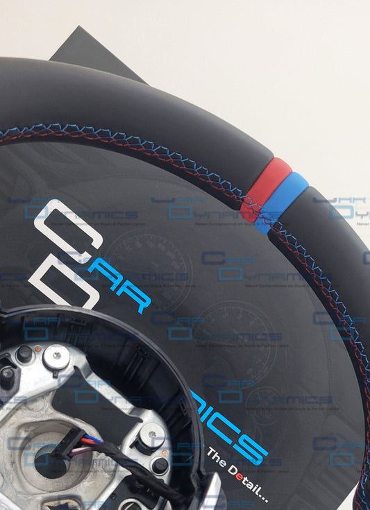 Close-up of a steering wheel with visible branding on a white background