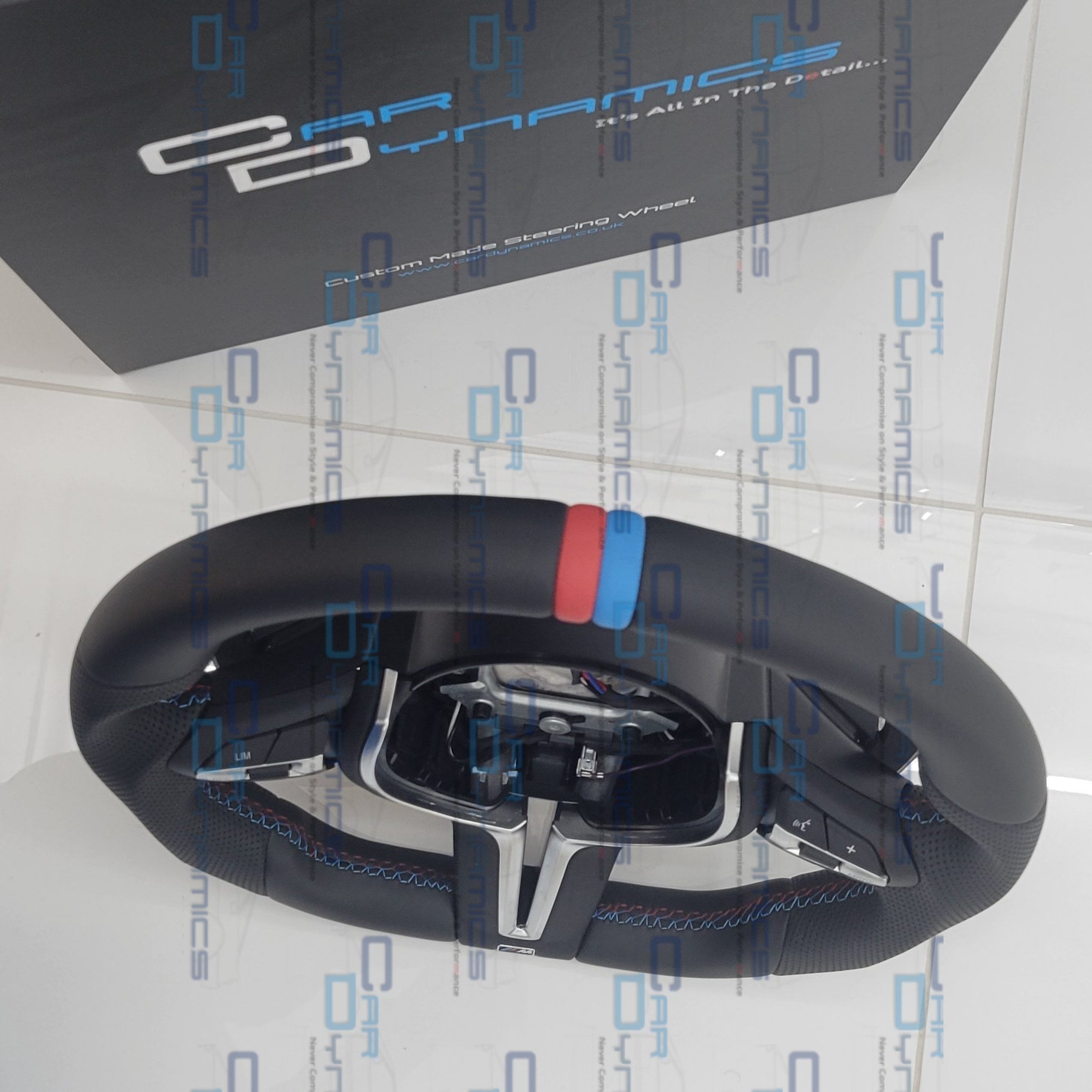 Steering wheel with 'Car Dynamics' branding on a branded background