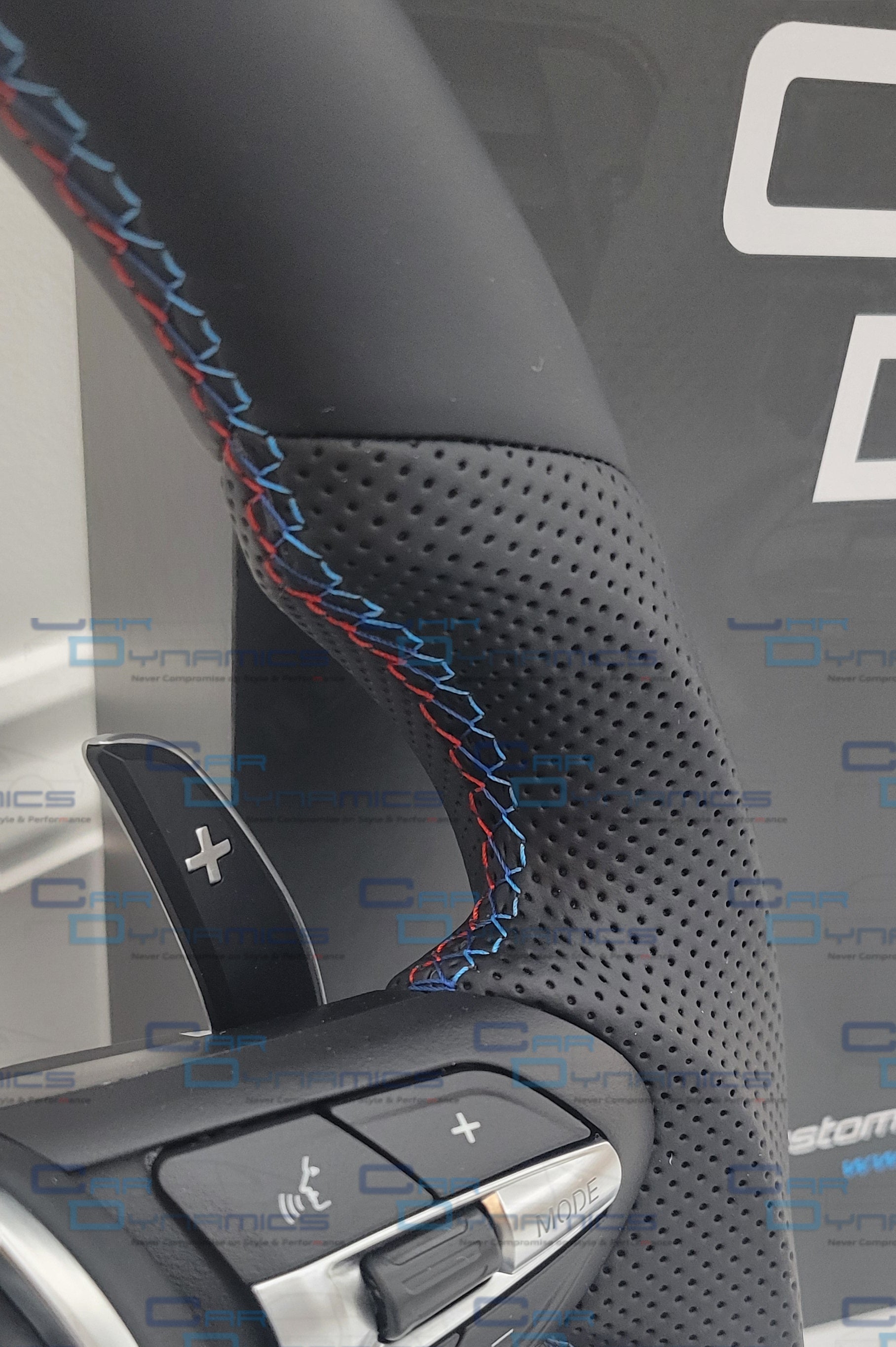 Close-up of a car steering wheel with control buttons on a blurred background